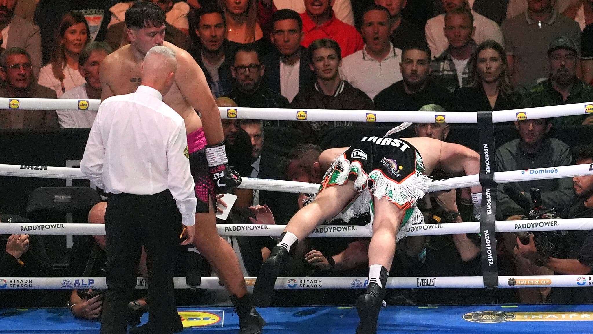 Carty falls through the ropes after receiving a blow to the back of the head from Allen
